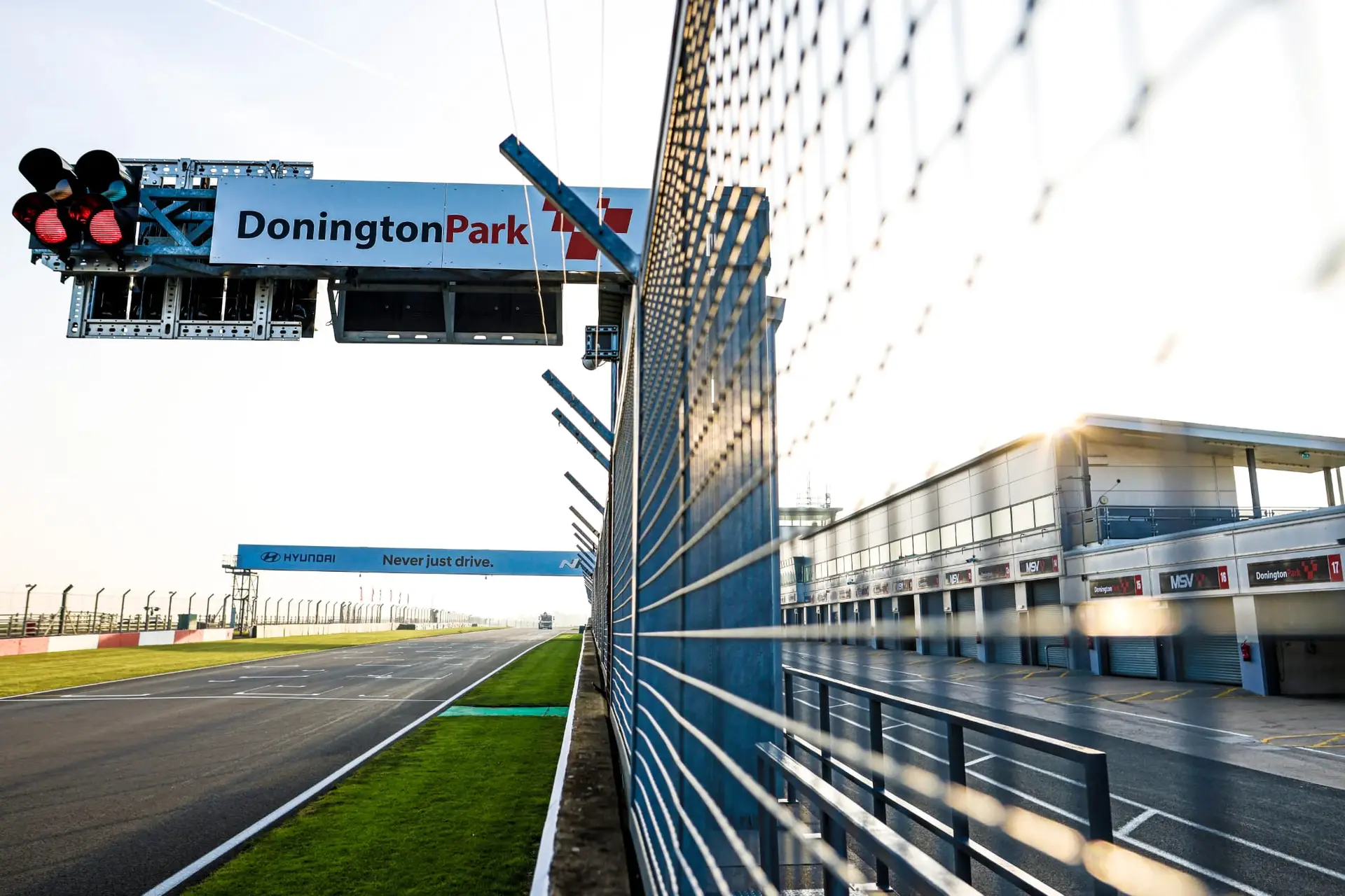 Donnington park photo down pit straight, wire mesh with donnington sign over gantry https://www.jakobebrey.com/