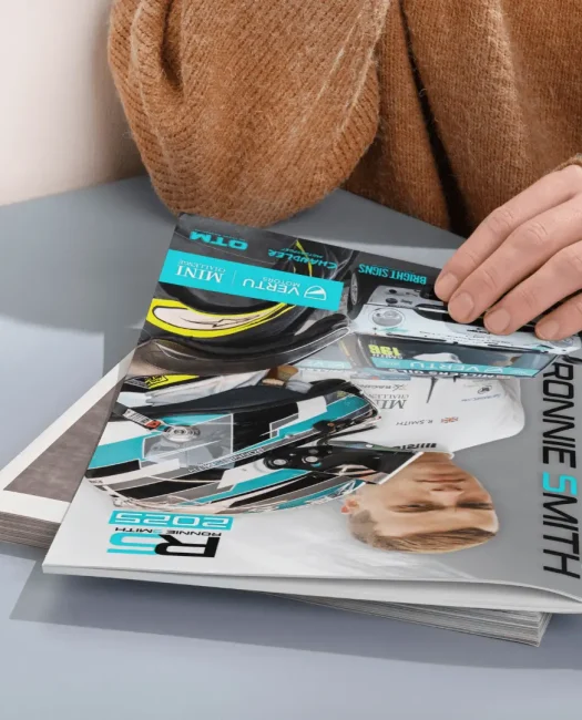 a person holding a stack of magazines